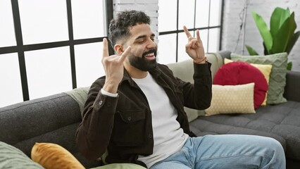 Poster - Maniac, young adult going mad at home, flaunting rockstar swagger, rocking hands in punk symbol, heavy music plays, screams in hipster joy