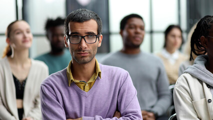 Wall Mural - Business trainer. A man gesturing with his hand while standing in front of a group of people