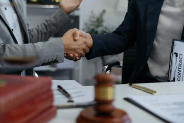 Middle age partner lawyers attorneys shaking hands after discussing a contract agreement done.