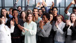 © Katsiaryna - Group of young businesswomen smiling happy and clapping. Standing and looking to the camera at the office.