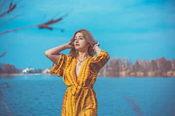 Wall Mural - Woman in yellow cotton dress and golden accessorize like a sun. Natural women's beauty without retouch, nature background