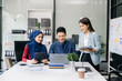 © Nuttapong punna - Happy businesspeople while collaborating on a new project in an office. Group of diverse businesspeople using a laptop and tablet ..