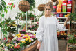 © olinchuk - Young woman in white dress at a glass greenhouse