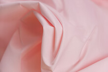 Close-up Of Texture Of Cotton Fabric Of Light Pink Color. Background, Texture Of Draped Fabric Without Patterns.