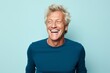 Portrait of happy senior man laughing. Isolated on blue background
