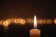 Nahaufnahme einer Kerzenflamme in einem schwach beleuchteten Raum, die das Licht des Glaubens und der Hoffnung in religiösen Ritualen und Zeremonien symbolisiert.