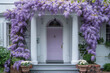 A whimsical house with a pink door stands out against a backdrop of vibrant purple wisteria, creating a dreamy and picturesque scene
