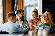 © Drazen - Happy family talking while eating at dining table in restaurant.