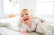 © Louis-Paul Photo - Baby boy in white sunny bedroom. one years child relaxing in bed.