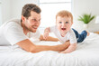 © Louis-Paul Photo - bearded father holding baby boy on bed, fatherhood and love