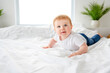 © Louis-Paul Photo - Baby boy in white sunny bedroom. one years child relaxing in bed.