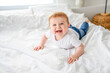 © Louis-Paul Photo - Baby boy in white sunny bedroom. one years child relaxing in bed.