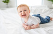 © Louis-Paul Photo - Baby boy in white sunny bedroom. one years child relaxing in bed.