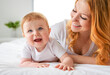 © Louis-Paul Photo - Mother and baby boy on bed, having great moment together on white bedroom
