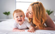 © Louis-Paul Photo - Mother and baby boy on bed, having great moment together on white bedroom