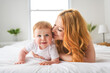 © Louis-Paul Photo - Mother and baby boy on bed, having great moment together on white bedroom