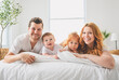 © Louis-Paul Photo - happy family mother, father and children having fun in bed in bedroom at home