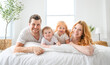 © Louis-Paul Photo - happy family mother, father and children having fun in bed in bedroom at home