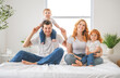 © Louis-Paul Photo - happy family mother, father and children having fun in bed in bedroom at home