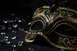 Close-up view of Masquerade gold mask with gemstones on black background.