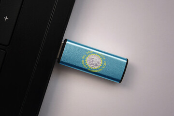 Wall Mural - usb flash drive in notebook computer with the national flag of south dakota state on gray background.