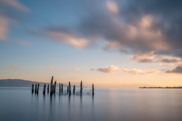 Wall Mural - Ruins of wooden pier in the beach sea and sky with sunset light