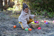 Adorable little girl collecting Easter eggs outdoors