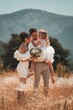 Capturing the beauty of love and family with stunning outdoor photograph featuring a young married couple embracing their adorable daughter.