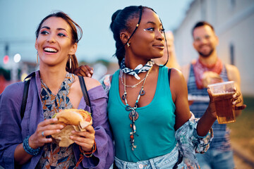 Wall Mural - Young women enjoying in beer and burger during summer music concert outdoors.