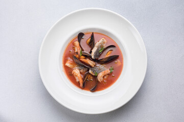 Wall Mural - Seafood soup with salmon and mussels in a white plate