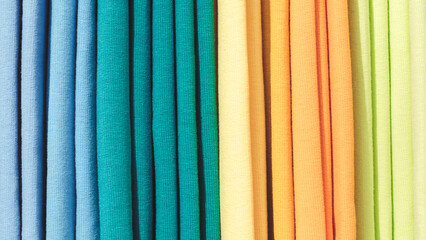 Poster - Multi-colored textile fabrics hang in a market or store as an abstract background