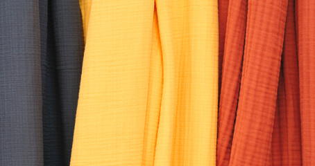 Poster - Multi-colored textile fabrics hang in a market or store as an abstract background