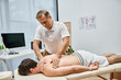 © LIGHTFIELD STUDIOS - good looking mature doctor in uniform massaging his patient while in hospital ward, rehabilitation