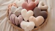 A collection of soft, plush pillows arranged in a heart shape on a cozy baby blanket.