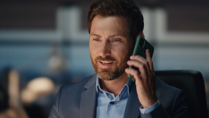 Wall Mural - Bearded man answering call at night corporate office closeup. Man talking phone