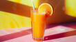 A glass of orange juice with a straw in it