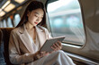 Photo of asian businesswoman traveling on train and reading important documents. Woman in a business suit