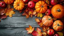 Vivid Pumpkins, Fresh Apples, And Multicolored Leaves Arranged On A Rustic Wooden Background For A Harvest Display.