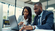 © Studio Nova - professional man and woman discussing work while looking at a laptop screen together in an office setting