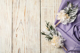 Fototapeta  - Stylish boutonnieres and purple fabric on light wooden table, top view. Space for text