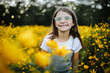 © Maria Manco/Stocksy - Preteen smiles at camera in wildflower field