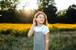 © Maria Manco/Stocksy - Preteen smiles at camera in wildflower field