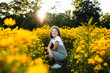 © Maria Manco/Stocksy - Preteen smiles at camera in wildflower field