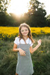 © Maria Manco/Stocksy - Preteen smiles at camera in wildflower field