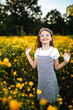 © Maria Manco/Stocksy - Preteen smiles at camera in wildflower field