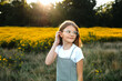 © Maria Manco/Stocksy - Preteen smiles at camera in wildflower field