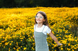 © Maria Manco/Stocksy - Preteen smiles at camera in wildflower field