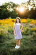 © Maria Manco/Stocksy - Preteen smiles at camera in wildflower field