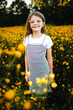 © Maria Manco/Stocksy - Preteen smiles at camera in wildflower field