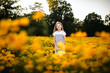 © Maria Manco/Stocksy - Preteen smiles at camera in wildflower field